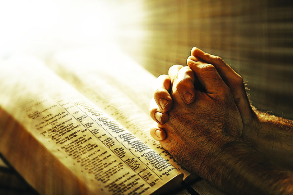 Man praying over a Bible