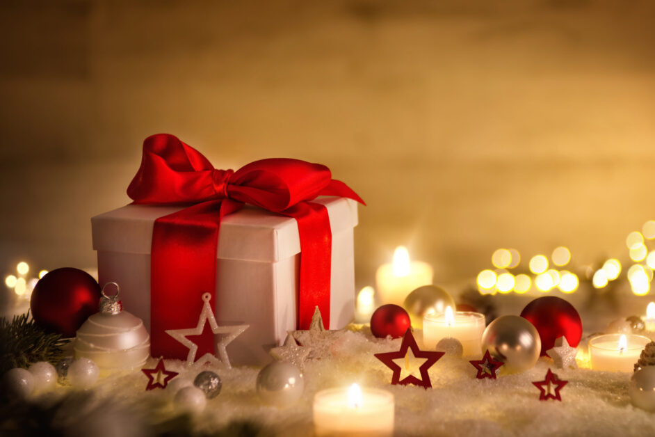 Weihnachten Hintergrund mit Geschenk und rotem Band, Kerzen, Lichterkette, Weihnachtsdeko und Schnee