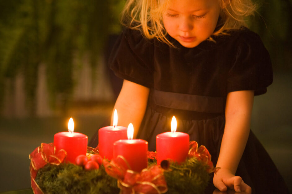 Kind mit Adventskranz zu Weihnachten